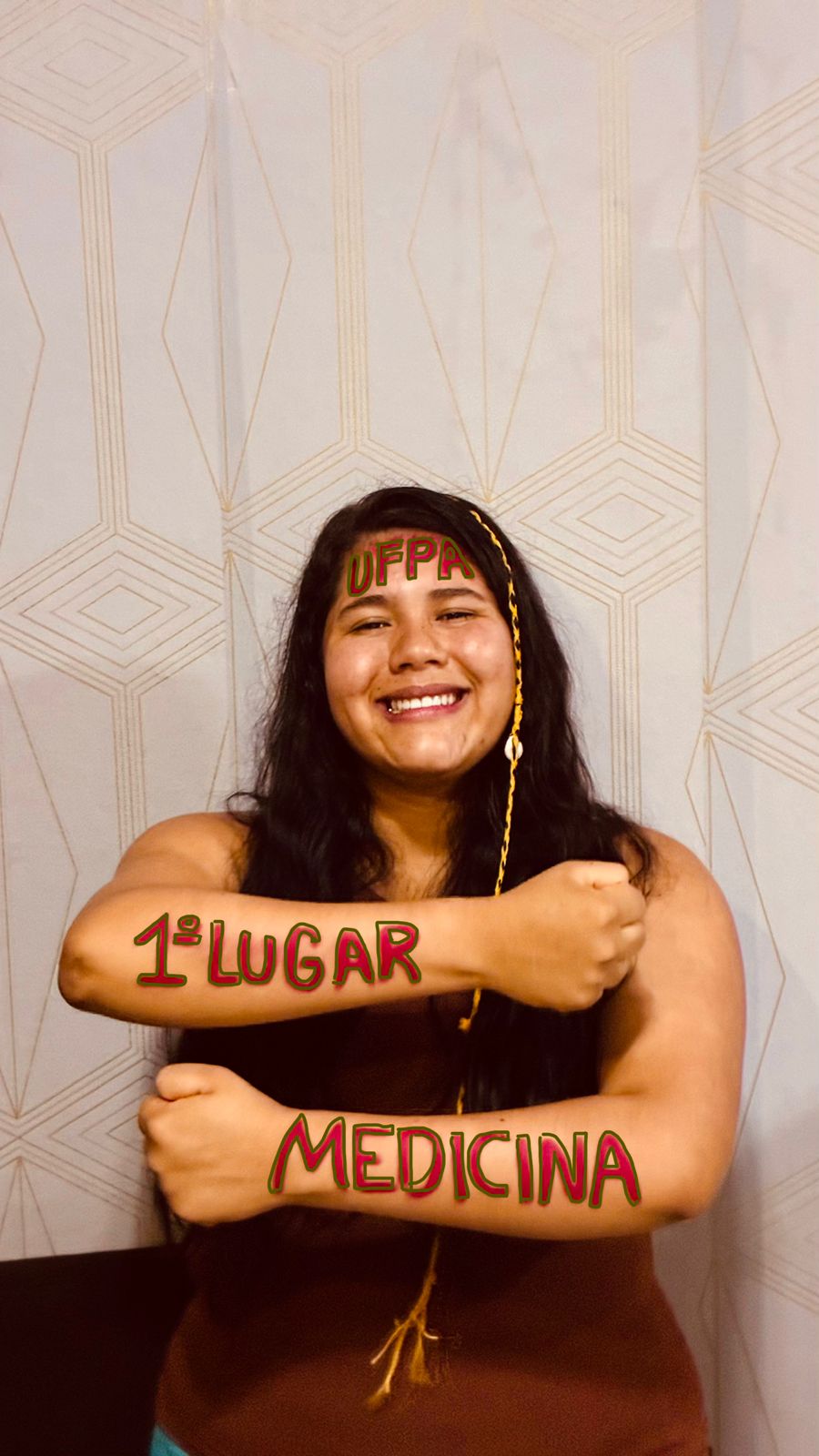 A aluna posa para a foto com "1º lugar - Medicina - UFPA" escrito nos braços